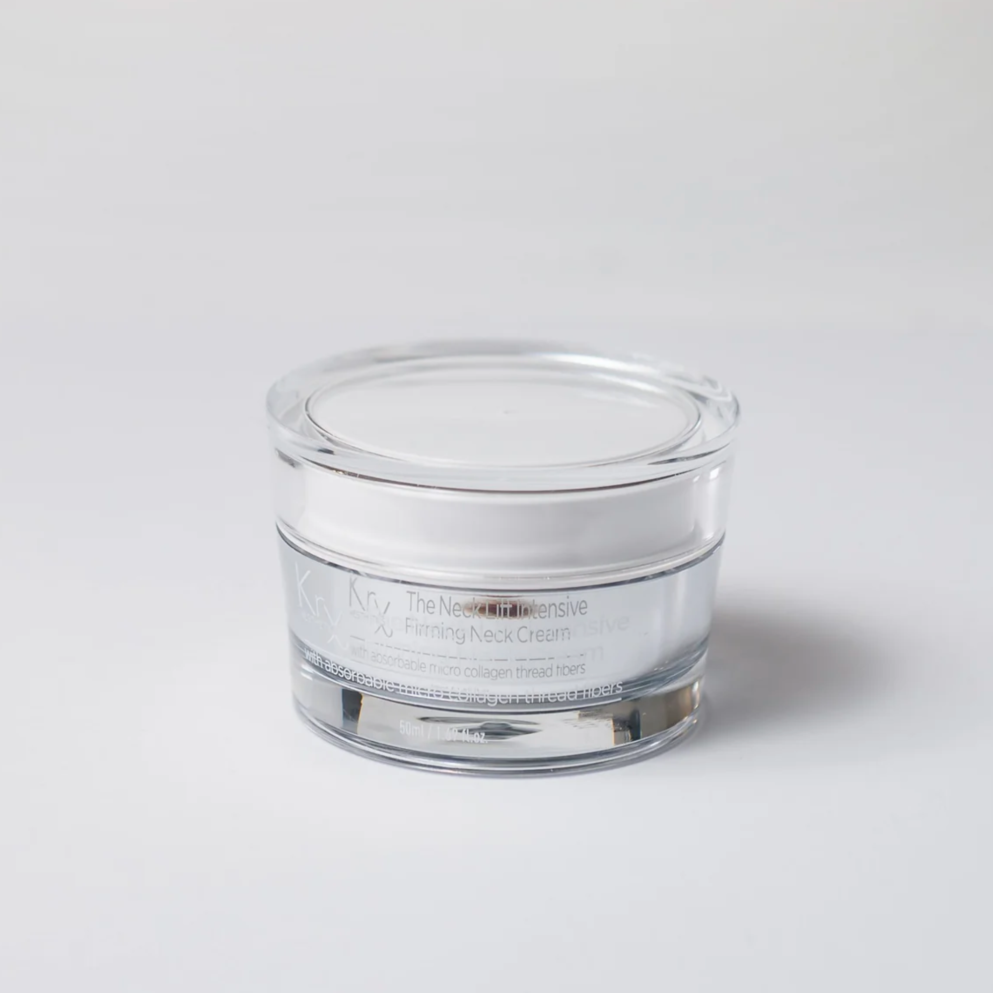 Clear glass jar with white cream on a light gray background