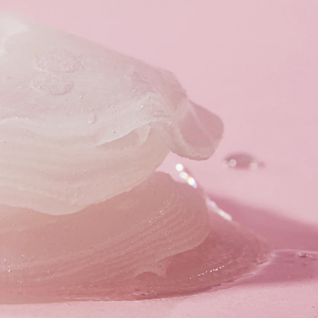 Close-up of a white, fluffy substance on a pink background