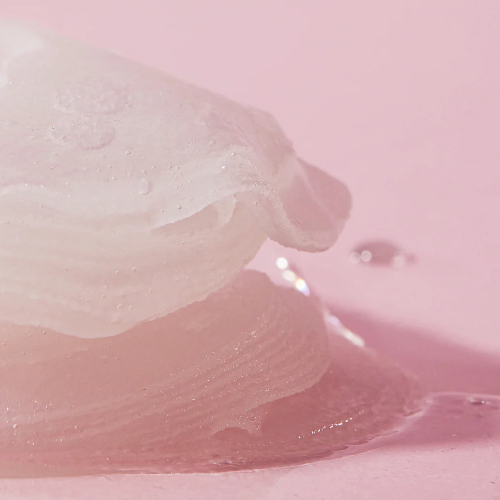Close-up of a white, fluffy substance on a pink background